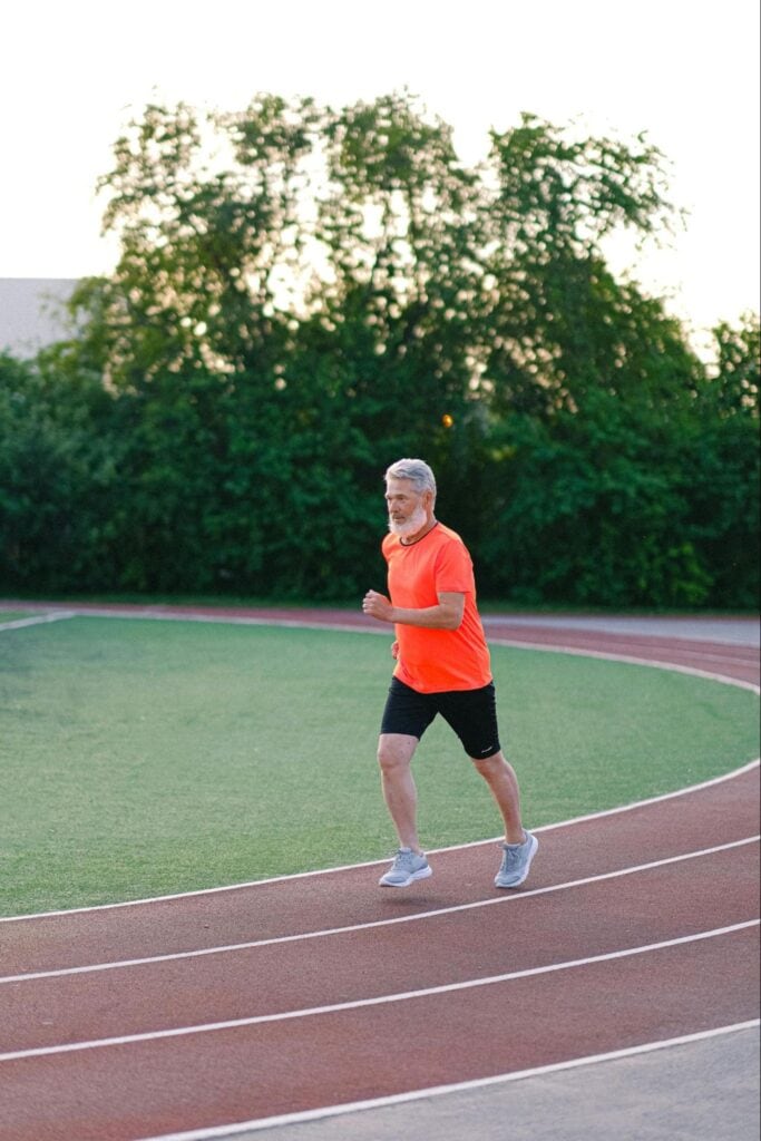 Man with white beard running on track